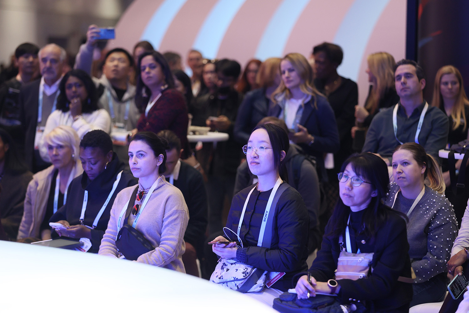 CES attendees seated and standing while watching the CTA Stage.