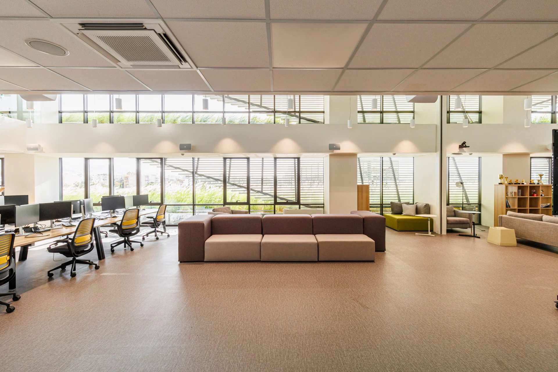 Open plan OpenBet office with desks, monitors and lounge seating in Marousi.